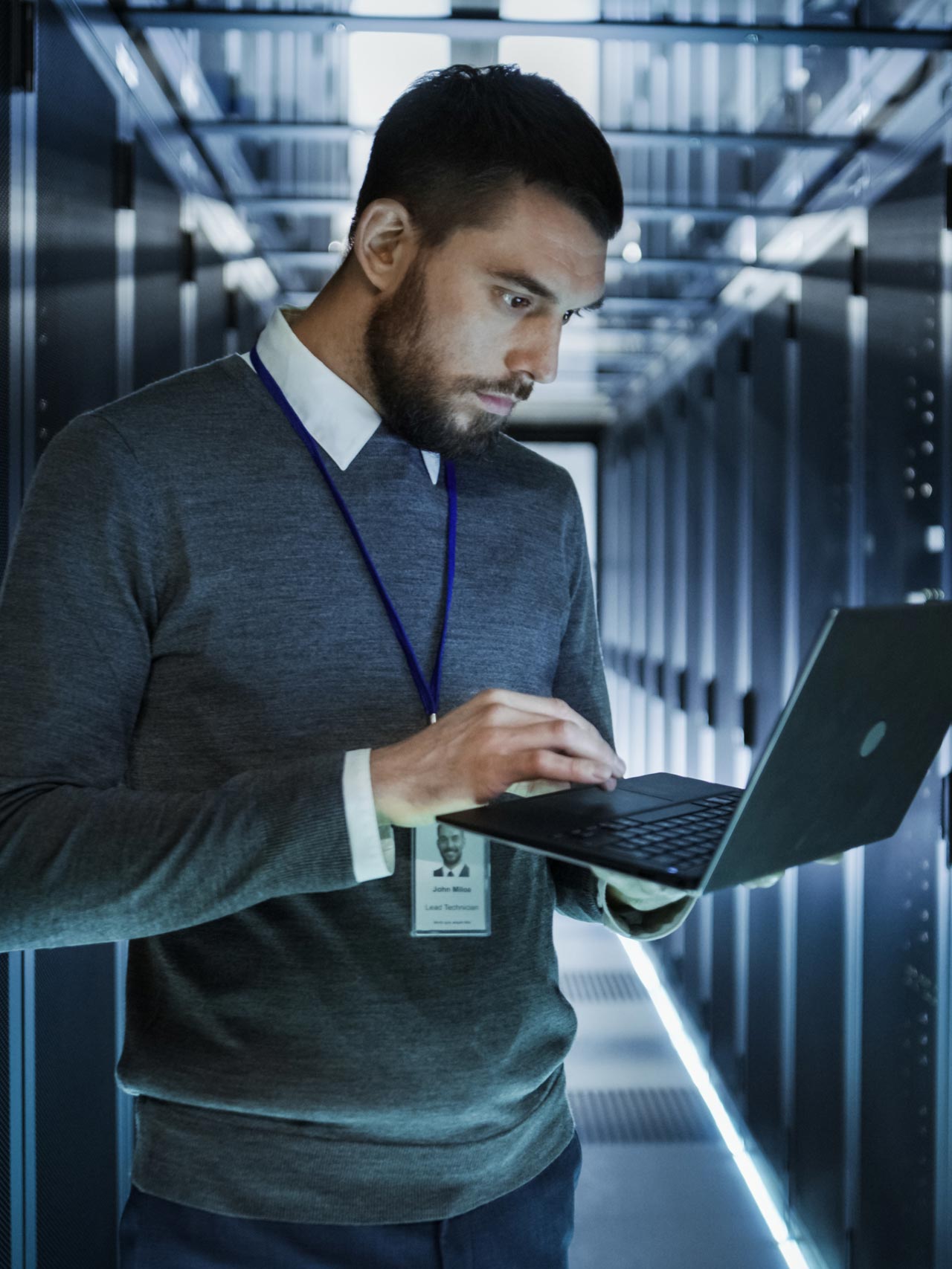 Man with a laptop and data center in the background
